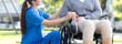 © NT_studio - Young caucasian nurse comforting with patient while sitting on wheelchair in outdoor park, doctor woman support and counseling with patient, caregiver and service, medical and consoling.