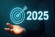 © Haseeb - Businessman holding glowing target with arrow and 2025 goal in futuristic interface