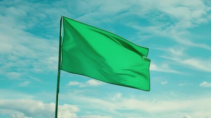 Wall Mural - A bright green flag is proudly displayed against a sunny, cloudless background