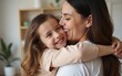 © Riley - Close up side view overjoyed smiling young mother and daughter hugging and laughing, enjoying tender moment, happy mum and adorable preschool girl kid cuddling, having fun together at home