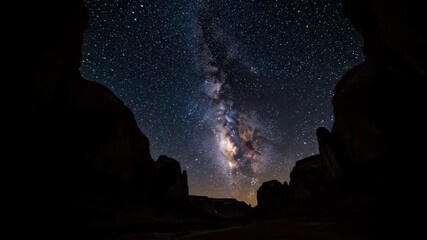 Wall Mural - The majestic Milky Way galaxy is framed by towering canyon walls as it slowly traverses the dark night sky in a breathtaking timelapse night sky, rugged, astronomy
