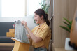 © Natee Meepian - Exciting Unboxing. Young woman delighted to receive a new sweater from online shopping.