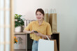 © Natee Meepian - Shopping and Digital Engagement. Young woman using smartphone after shopping.
