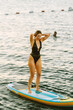 © ardasavasciogullari - Brunette Woman Paddleboarding with Yachts Background