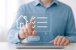 © Haseeb - Person using tablet with holographic real estate property checklist