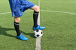 © Mediaphotos - Teenager boy standing on soccer field placing foot on soccer ball wearing athletic uniform, showing lower body and legs, preparing for game or practice session outdoors