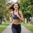 © Aleksandra - Young woman jogging happily on a pathway in a green park