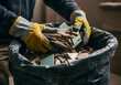 © Mahmuda - Worker wearing gloves throwing pieces of tile into a garbage bag for disposal