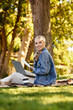 © LIGHTFIELD STUDIOS - Young woman enjoying a peaceful outdoor walk in a lively park while embracing natures beauty