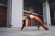 © BullRun - Young woman practicing yoga wild thing pose outdoors, one arm grounded, back arched, head tilted. Conceptual stock photo symbolizing empowerment, resilience, mindfulness, and digital wellness.