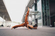 © BullRun - Young woman in advanced yoga forearm balance variation on pavement, leg lifted behind. Conceptual stock image symbolizing empowerment, mindfulness, resilience, strength, and wellness.