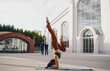 © BullRun - Young woman balancing in forearm stand variation outdoors on yoga mat. Conceptual fitness photo symbolizing mindfulness, empowerment, strength, resilience, and wellness lifestyle.