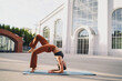 © BullRun - Female athlete transitioning from forearm stand into backbend variation on yoga mat. Conceptual fitness stock image symbolizing empowerment, resilience, flexibility, and mindful wellness.