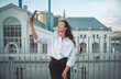 © BullRun - Smiling woman waves while taking selfie with smartphone. Conceptual photo symbolizing digital connection, online identity, self-expression, empowerment, and modern technology culture.