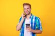 © be free - Millennial man has phone call holding coffee. Man talk on cellphone. Phone call. Mobile connection. Guy with coffee. Student lifestyle. Modern communication. Man speak on phone isolated on yellow