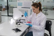 © Freeday photo - Scientist conducting research using a microscope and pipette in a modern laboratory setting