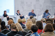 © Anton Gvozdikov - Group of people attending a conference with audience focusing on speakers panel session