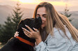 © KatyaPulka - A serene moment captured as a woman embraces her black Labrador retriever in a warm, scenic outdoor setting during golden hour. Focus on love, nature, and companionship.