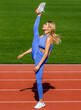 © Yevhen - Leg-split, stretching in the stadium. Athletic fitness woman leg split is exercising outdoors. Young fit slim woman is doing stretch legs