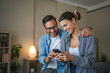 © Miljan Živković - Happy couple enjoying smart phone together at home