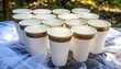 © Paringi - White cups with gold and green designs arranged on a table