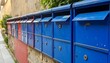 © Alviana - Row of colorful mailboxes against a weathered wall