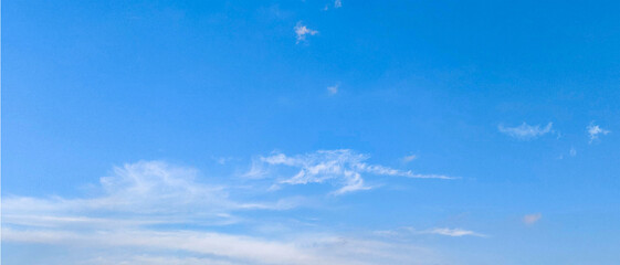 Wall Mural - blue sky and wispy clouds. a serene view of a bright blue sky adorned with wispy, delicate white clo