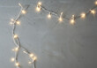 © NexusGallery - String lights glow softly creating a festive ambient illumination on gray textured surface