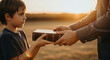 © Светлана Воротняк - Man giving Bible book to boy at sunset. Religious education concept. Christian tradition for future generation.