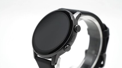 An elegant black smartwatch with a dark, unlit screen is prominently showcased against a clean white backdrop, highlighting advanced wearable technology.