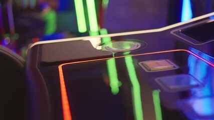 A detailed closeup view of a vibrant gaming machine control panel featuring colorful buttons and bright lights