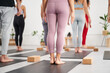 © CarlosBarquero - Unrecognizable group of yoga students in class. Back view of standing diverse people practicing asanas indoors. Concept of healthy living and mental health.