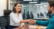 © wakhid saiful anam - A smiling businesswoman shaking hands with a businessman in a modern office setting, signifying a successful business deal, partnership, or job interview