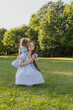 © Татьяна Зернова - Daughter hugs and kisses her mother in the sunlight, wearing blue dresses. Close-up portrait of happiness. Family concept, interaction between parents and children