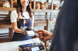 © Dragana Gordic - Smiling Barista Accepting Card Payment With Portable Reader In Cozy Bakery Shop