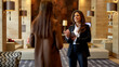 © PeopleVideos - Hotel staff member welcoming guest, offering professional service and hospitality with tablet during check-in