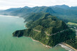 © Connect Images - Aerial view of lush green landscape with a prominent coastal hill and vast ocean backdrop. Aceh Jaya Regency, Aceh, Sumatra, Indonesia
