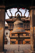 © Connect Images - Large vintage bell with ornate details hangs between ancient stone pillars. Nyatapau Temple, Bhaktapur, Nepal