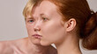 © master1305 - Close side profile of red-haired woman with blond man blurred behind on neutral background. Concept of gender identity, individuality, emotional portraiture, modern editorial photography.