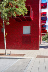 Modern architecture with bold red facade and urban street, copy space suitable for branding, editorial design and corporate layouts