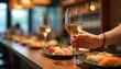 © Viktor - Woman holds wine glass with sushi spread on bar counter. Enjoying fine dining meal with drink. Festive celebration atmosphere. Indoor restaurant setting.
