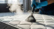 © W.O.W - Person cleaning mattress with a steam cleaner. Disinfection and sterilization of bed surface. Professional home cleaning service.