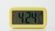 © stockbusters - Closeup electric clock display showing time and date. Modern yellow timepiece