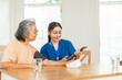 © CandyRetriever  - Asian woman doctor measuring blood pressure to senior female patient at nursing home. Caregiver or nurse taking care elderly people. Home medical healthcare services and health insurance concept.