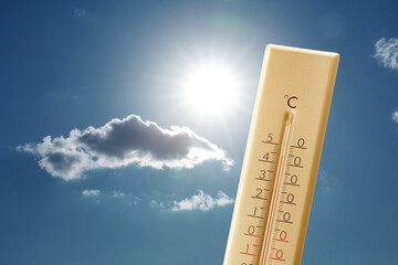 Wall Mural - high temperature on thermometer against blue sky with clouds and bright sun. extremely hot weather