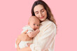 © Pixel-Shot - Happy mother with her little baby on pink background. IVF concept
