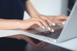 © tippapatt - Woman working at home office. Casual business woman hand typing on laptop computer keyboard on white office table, close up. online job, surfing the internet, remote work concept