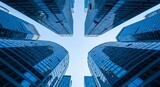 Lowangle view looking up at modern skyscrapers with glass facades reflecting the sky, creating a symmetrical, architectural pattern symbolizing urban growth and business