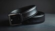 © Kabel - A sleek, black leather belt with a silver buckle rests on a dark surface, subtly coiled.  The belt's textured leather is visible