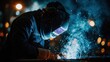© Popa - Welder at Work - Intense Blue Sparks and Protective Gear in Dark Industrial Setting.